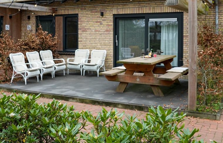 Buitenruimte met hot tub omgeven door groen bij Vakantiehuisje in Dwingeloo, Drenthe.