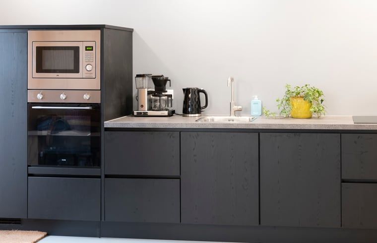 Gezellige eetkamer in Vakantiehuisje in Dwingeloo, Zuidwest Drenthe, met houten tafel en sfeerverlichting.