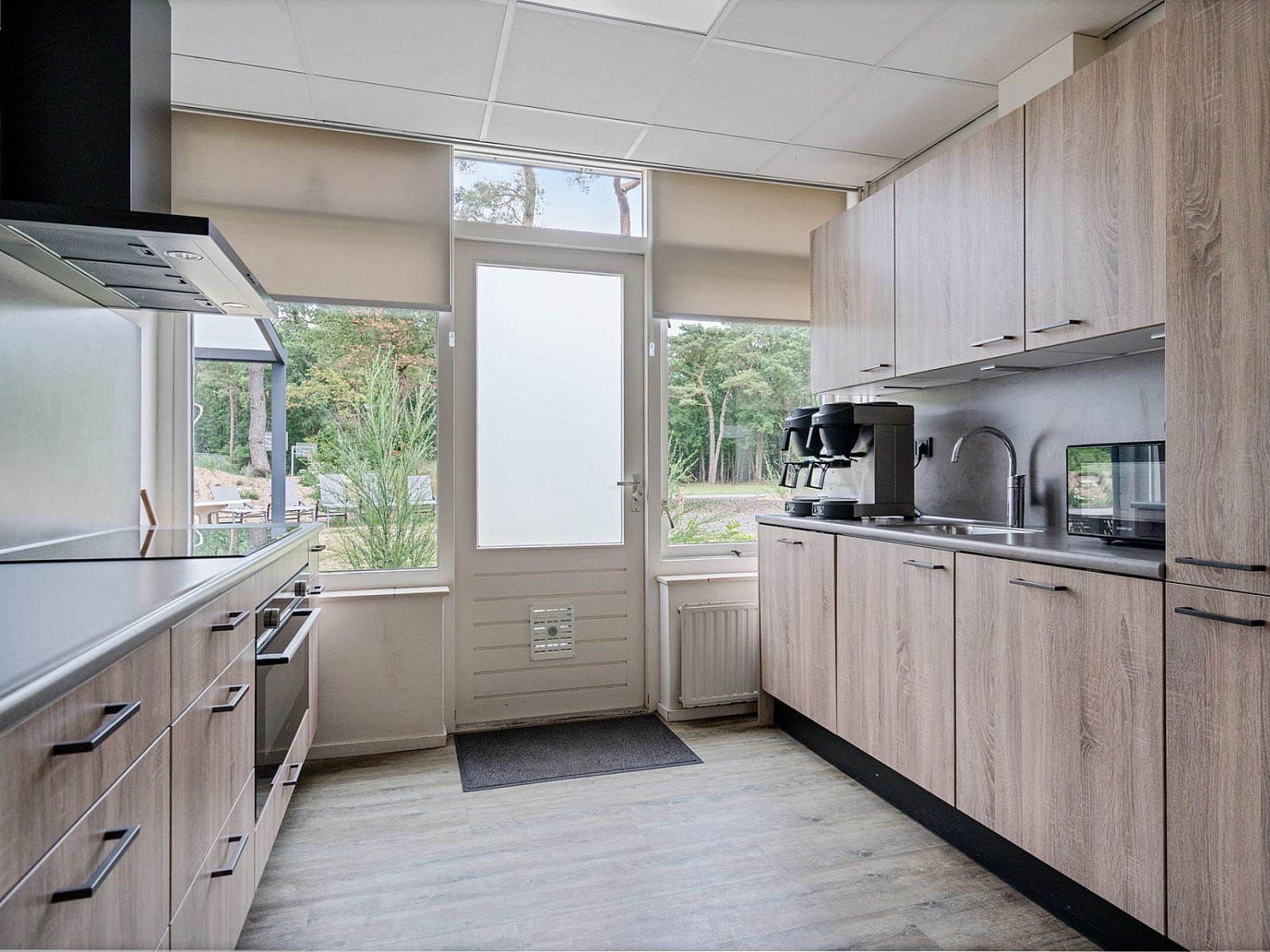 Moderne keuken in Groepsaccommodatie de Komeet in Dwingeloo, Zuidwest Drenthe, met uitzicht op de groene natuur.