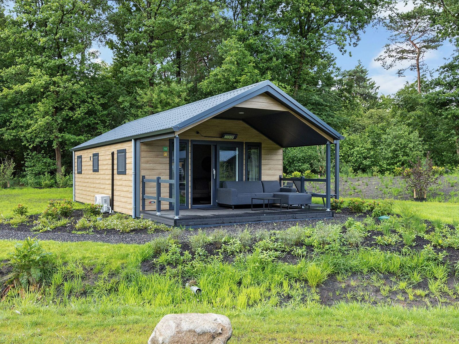 Chalet Sedna in Dwingeloo, Drenthe, bietet eine gemuetliche Veranda inmitten gruener Natur.