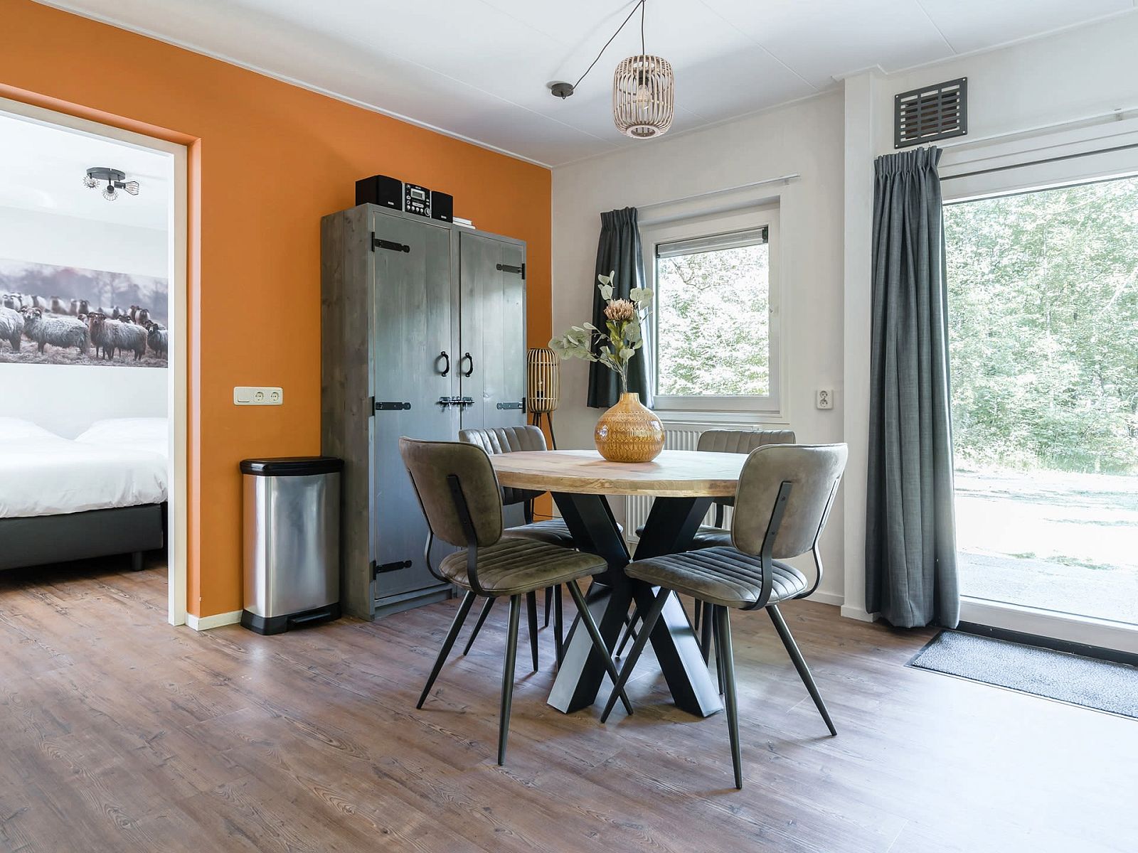 Gemuetlicher Innenbereich des Bungalows Jupiter in Dwingeloo, Drenthe, mit moderner Einrichtung und Blick auf die gruene Umgebung.