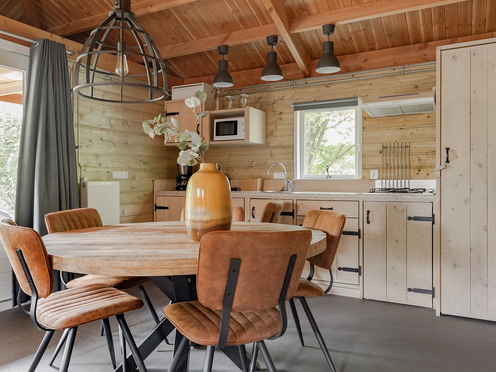 Cozy kitchen and dining area in Hooiberglodge, a vacation home in Dwingeloo, Southwest Drenthe, with wooden interior and modern amenities.