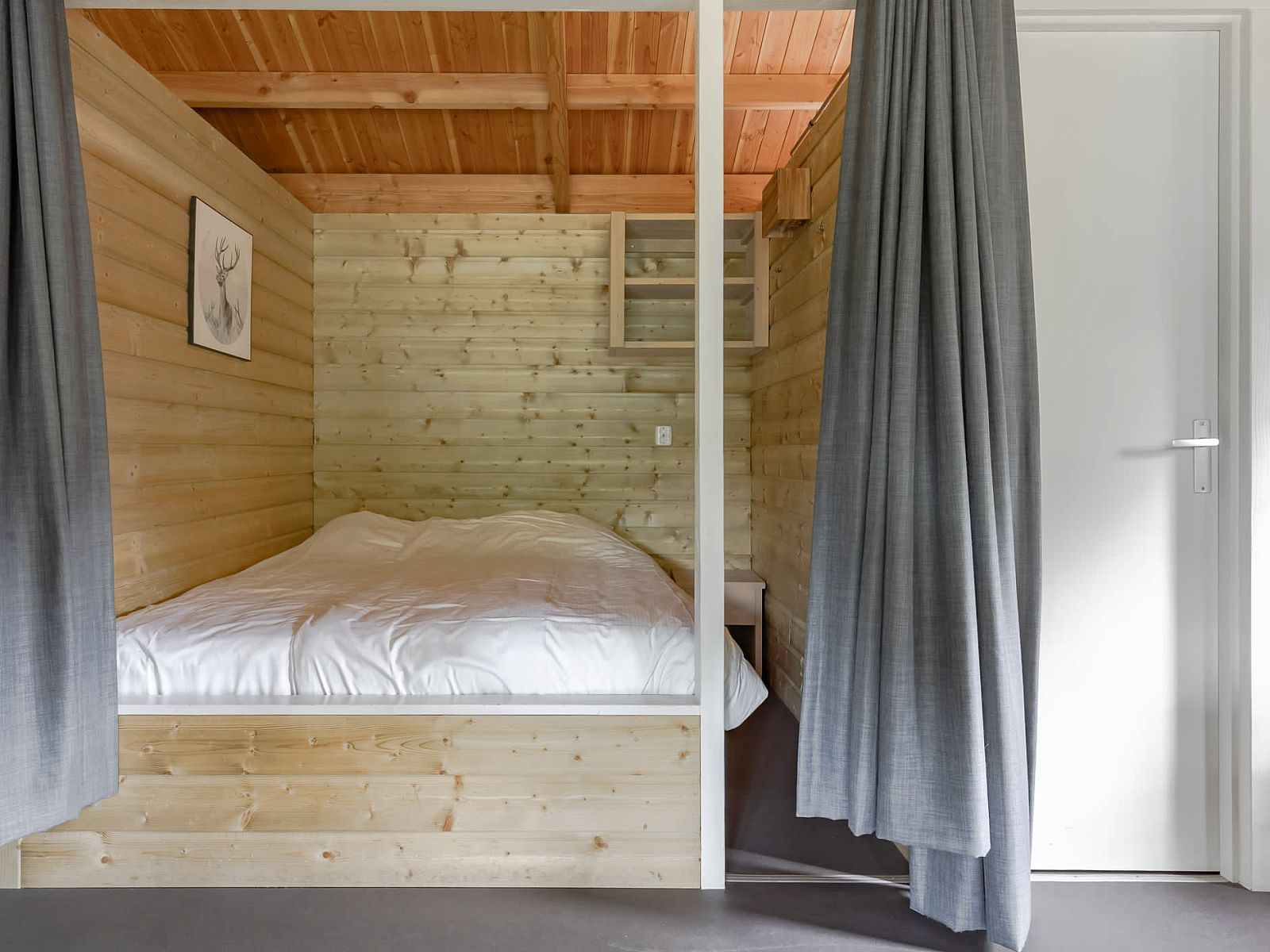 Attractive bedroom in the Hooiberglodge, a vacation home in Dwingeloo, Southwest Drenthe, with wooden interior and cozy feel.