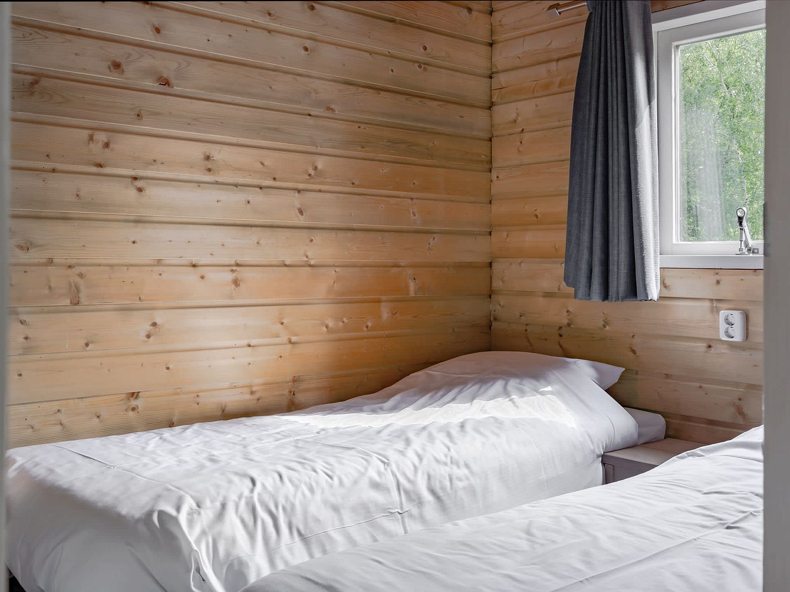 Cozy bedroom in Hooiberglodge, a vacation home in Dwingeloo, Drenthe, with wooden interior and views of nature.