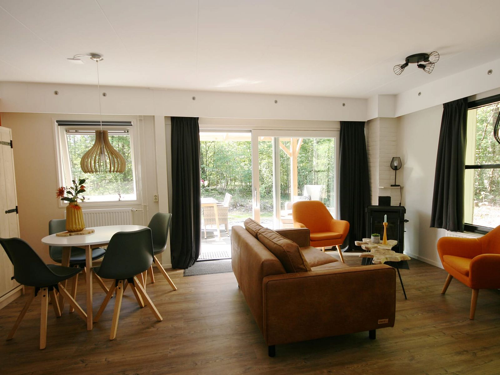 Gezellige woonkamer van Bungalow Mars in Dwingeloo, Zuidwest Drenthe, met uitzicht op terras en groene omgeving.