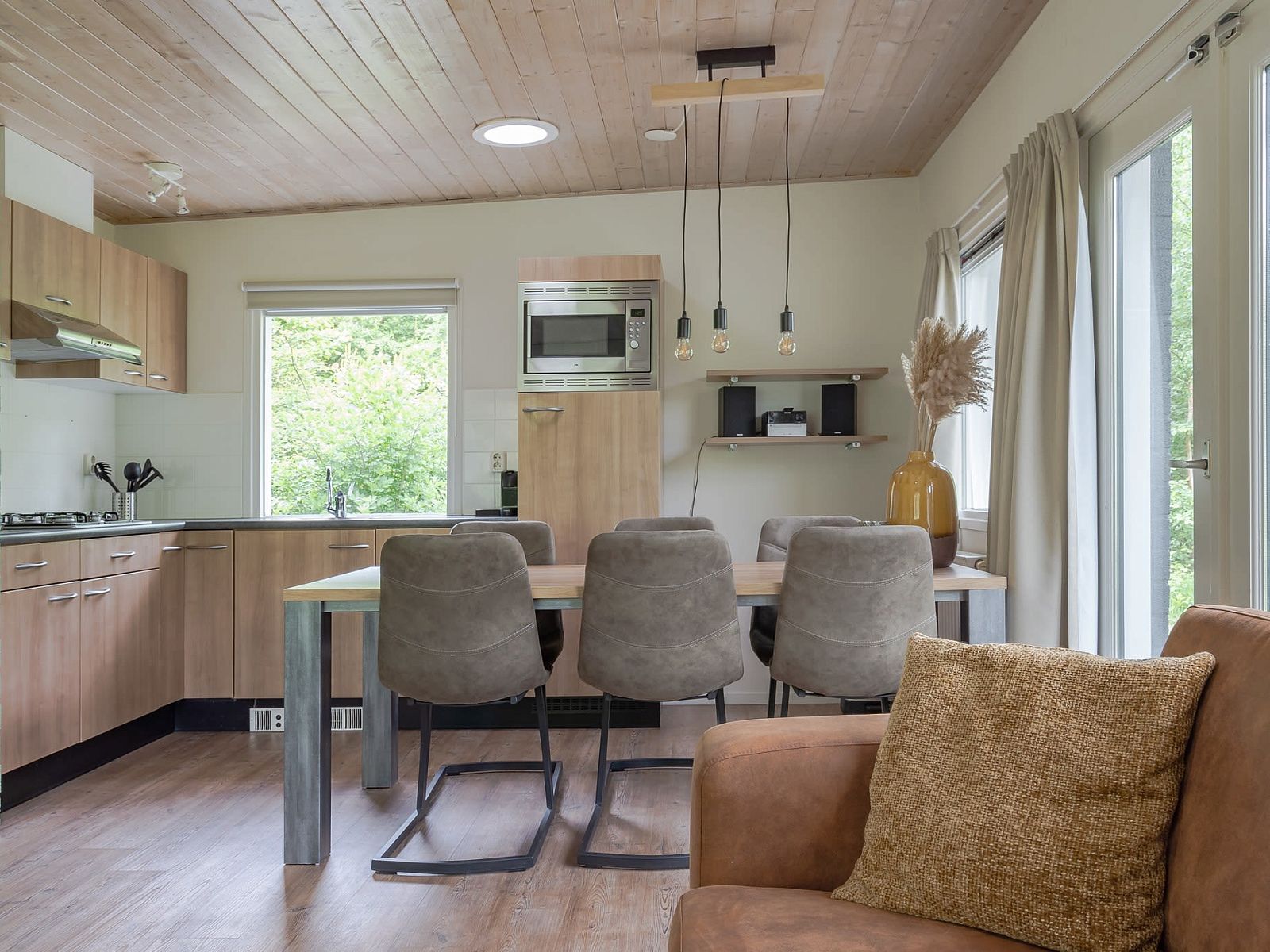 Gezellige binnenruimte van Bungalow Saturnus in Dwingeloo, Drenthe, met moderne keuken en eetruimte voor een ontspannen vakantieverblijf.