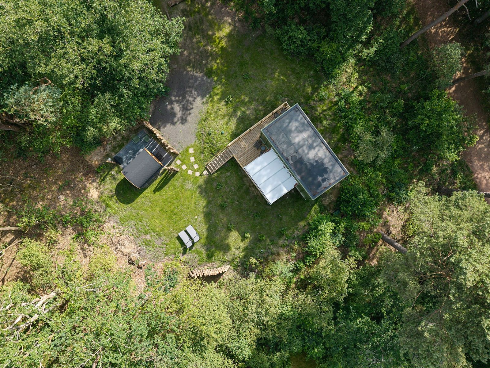 Luftaufnahme des Tiny House Eris mit Sauna, ein Ferienhaus in Dwingeloo, Suedwest-Drenthe, umgeben von ueppiger Natur und Gruen.