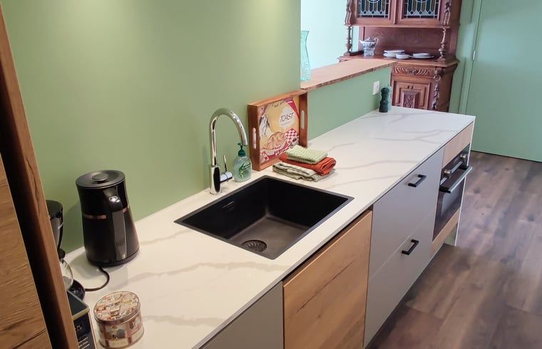 Moderne Kueche in einem Ferienhaus in Dwingeloo, Suedwest-Drenthe, mit glatter Oberflaeche und modernen Geraeten.