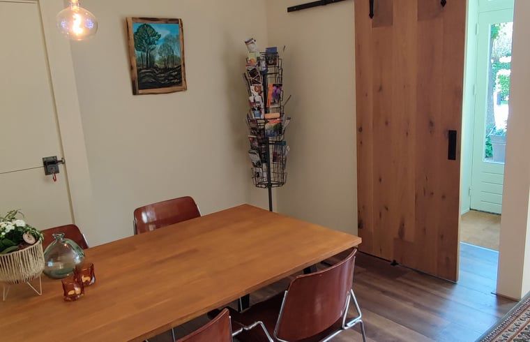 Esszimmer mit Holztisch im Ferienhaus in Dwingeloo, Suedwest-Drenthe, der perfekte Ort fuer gemuetliche Mahlzeiten.