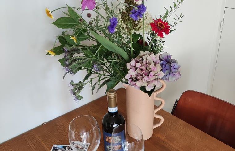 Ein frischer Blumenstrauss auf dem Tisch im Ferienhaus in Dwingeloo, Suedwest-Drenthe, sorgt fuer eine warme und einladende Atmosphaere.