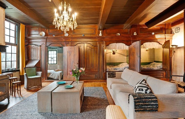 Gemuetliche Einrichtung des Ferienhauses in Ruinerwold, Drenthe, mit authentischem Kamin und gemuetlichem Bettgestell fuer einen stimmungsvollen Aufenthalt.