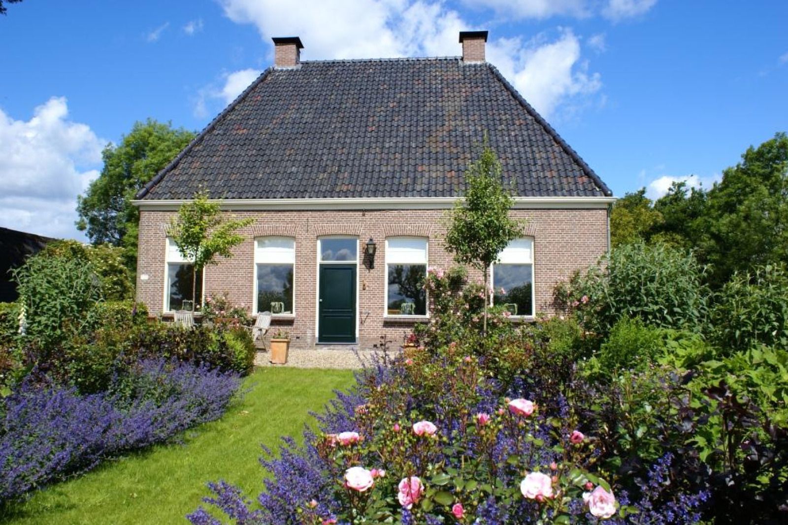 Vakantiehuis DG2051 in Ruinerwold, Zuidwest Drenthe, omgeven door een kleurrijke tuin en natuur, ideaal voor een ontspannen verblijf.