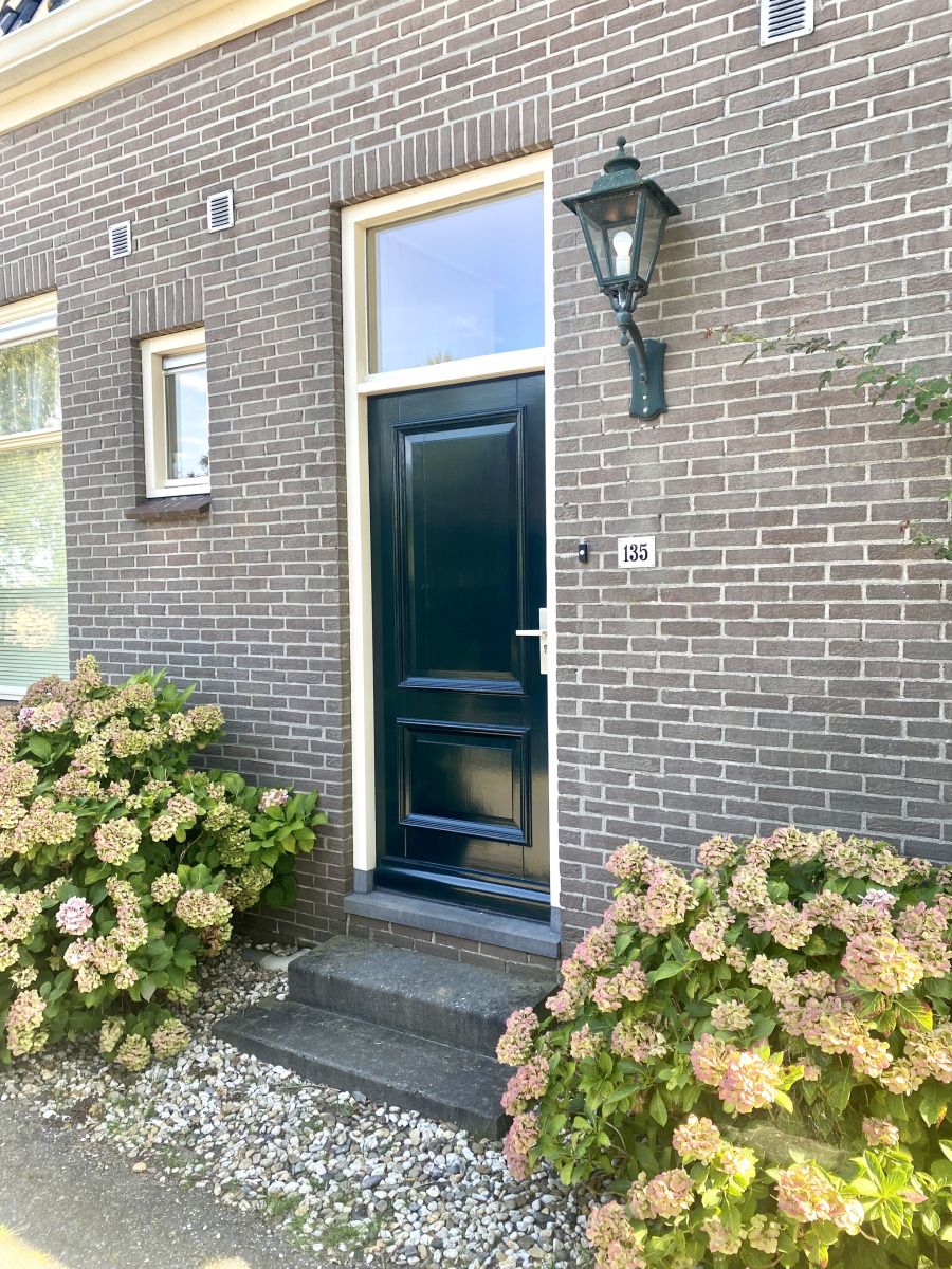 Geniet van de charmante buitenruimte van vakantiehuis DG2051 in Ruinerwold, Zuidwest Drenthe, met een gezellig terras en groene omgeving.