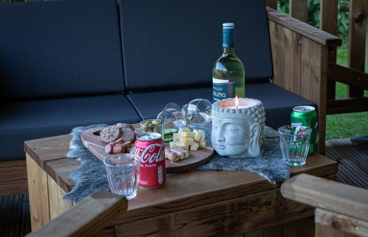Geniessen Sie einen entspannten Abend auf der Veranda des Ferienhauses in Ruinerwold, einem Ferienhaus im Suedwesten von Drenthe, mit einer stimmungsvollen Snackplatte.