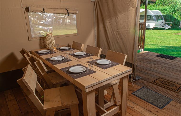 Gemuetlicher Essbereich im Ferienhaus in Ruinerwold, Ferienhaus im Suedwesten von Drenthe, mit Blick auf die gruene Umgebung und Terrasse.