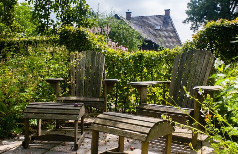 Bequeme Stuehle im Garten des Ferienhauses in Ruinerwold, ideal fuer Entspannung in Drenthe.