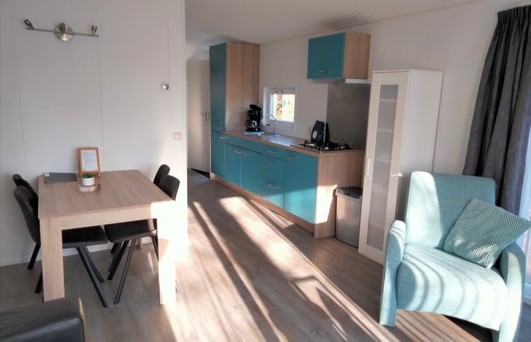 Moderne keuken in Huisje in Zorgvlied, Zuidwest Drenthe, met strakke blauwe kasten en uitzicht op de natuur voor een ontspannen verblijf.