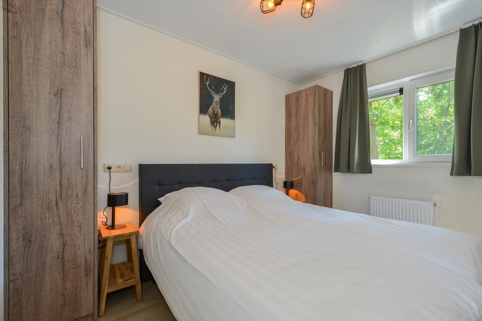 Sfeervolle slaapkamer in Drenthelodge | Berging | 6 Pers, Zorgvlied, Zuidwest Drenthe, met comfortabel tweepersoonsbed.