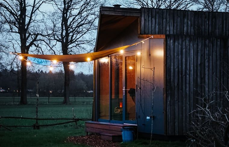 Cottage in Vledder at dusk, Southwest Drenthe, with atmospheric outdoor lighting.
