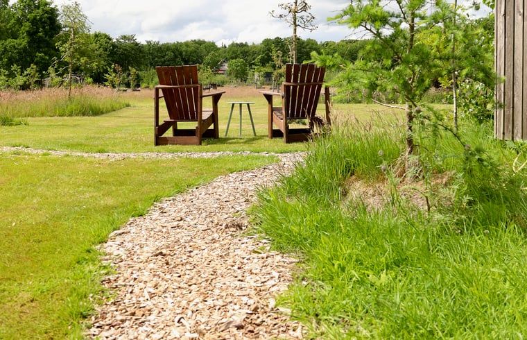 Path to wooden chairs in the garden of cottage in Vledder, southwest Drenthe.