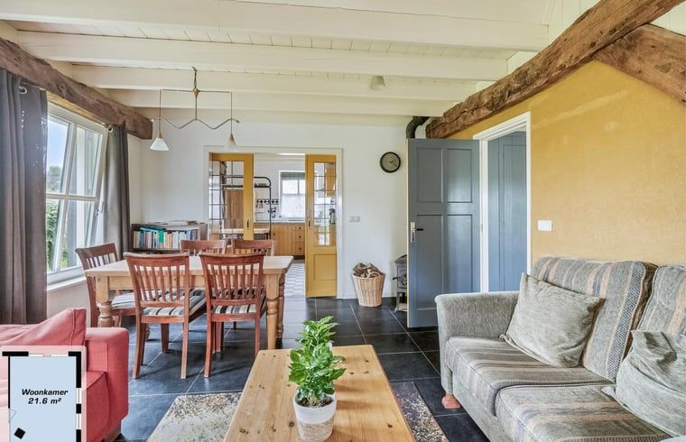 Gezellige woonkamer van Vakantiehuisje in Wapse, Zuidwest Drenthe, met houten balken en comfortabele zithoek voor een ontspannen verblijf.
