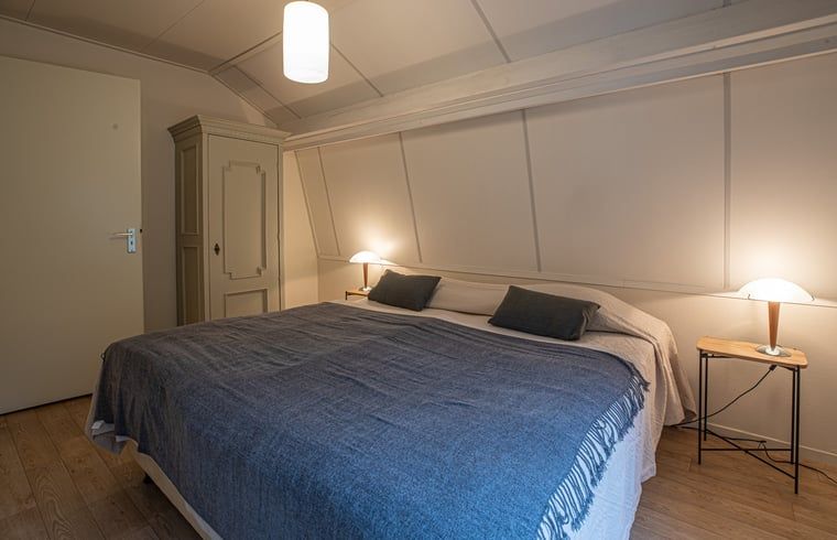 Geraeumiges Schlafzimmer mit Doppelbett in einem Ferienhaus in Wateren, Westerveld, im Suedwesten von Drenthe.