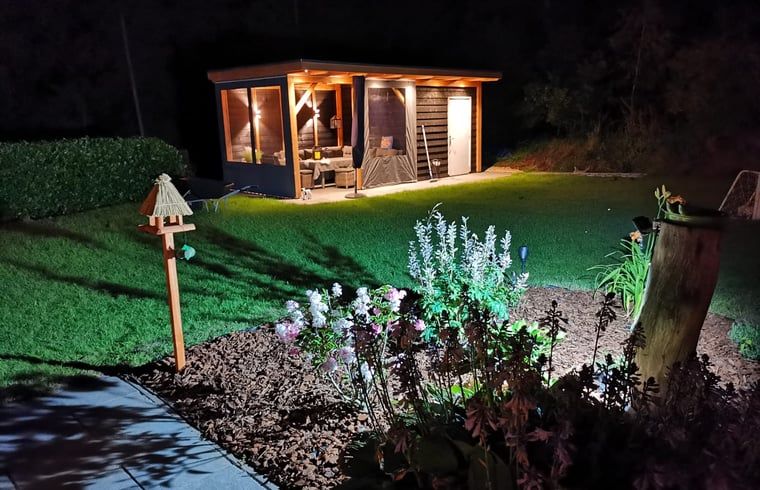Vacation home in Wittelte with attractively lit garden in Southwest Drenthe, perfect for evening relaxation.