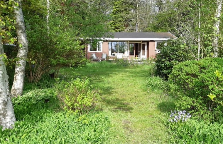 Front view of Cottage in Koekange, vacation home in Southwest Drenthe, surrounded by lush green garden.