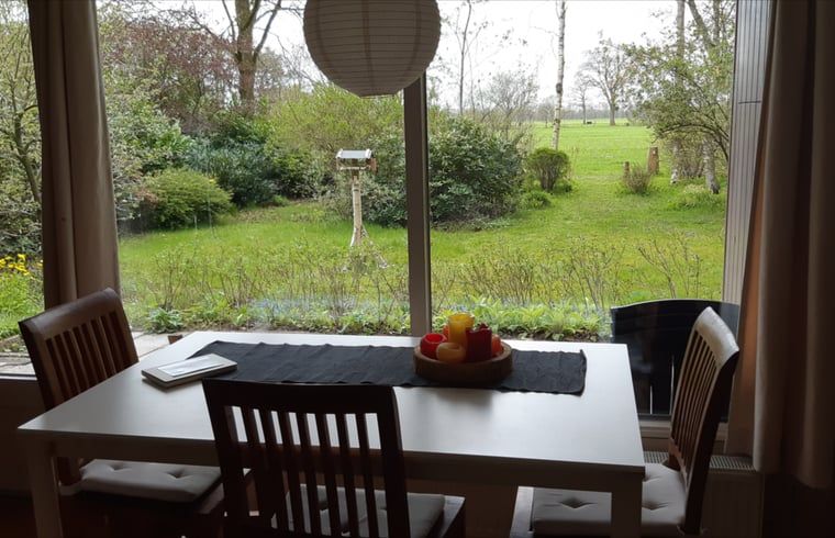 Dining table overlooking the garden in Cottage in Koekange, vacation home in Southwest Drenthe, perfect for family dinners.