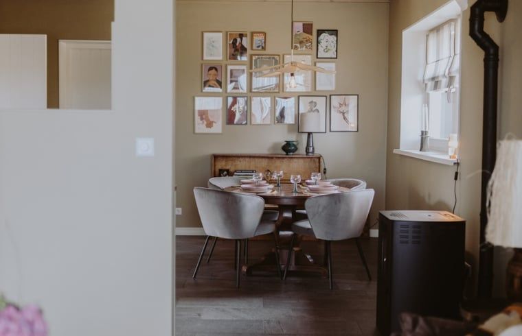 Gemuetliche Essecke im Ferienhaus in Uffelte, Suedwest-Drenthe, mit rundem Tisch und stilvollen Stuehlen.