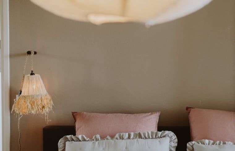 Ruhiges Schlafzimmer im Ferienhaus in Uffelte, Suedwest-Drenthe, mit romantischer Beleuchtung und sanften Farben.