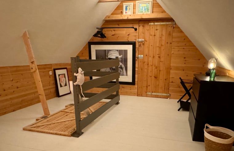 Gemuetlicher Dachboden im Ferienhaus in Ansen, Suedwest-Drenthe, mit Holzverkleidung.