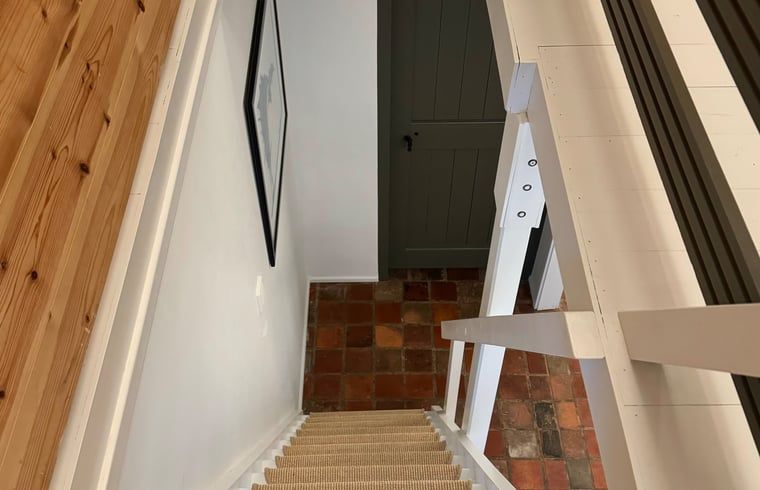 Treppe zum Dachboden in einem Ferienhaus in Ansen, Suedwest-Drenthe, mit Holzdetails.