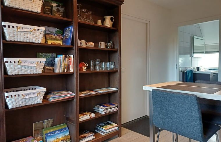 Boekenkast en eetgedeelte in Huisje in Veeningen, vakantieaccommodatie in Zuidwest Drenthe.