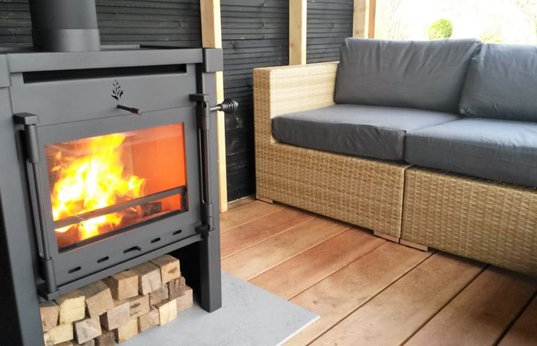 Houtkachel op veranda van Huisje in Veeningen, vakantiehuis in Drenthe.