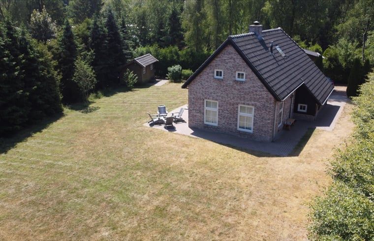 Luftaufnahme des Ferienhauses in Oude Willem, Suedwest-Drenthe, mit grossem Garten und gruener Umgebung.