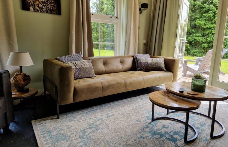 Gemuetliche Sitzecke im Ferienhaus in Oude Willem, Suedwest-Drenthe, mit Blick auf den Garten.