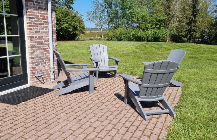 Terrasse des Ferienhauses in Oude Willem, Suedwest-Drenthe, mit Picknicktisch und bequemen Stuehlen.