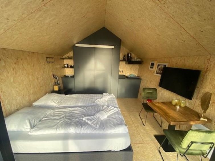 Comfortabele slaapkamer in Vakantiehuis Solo Retreat 2, Biddinghuizen, met uitzicht op de natuurlijke omgeving van Flevoland.