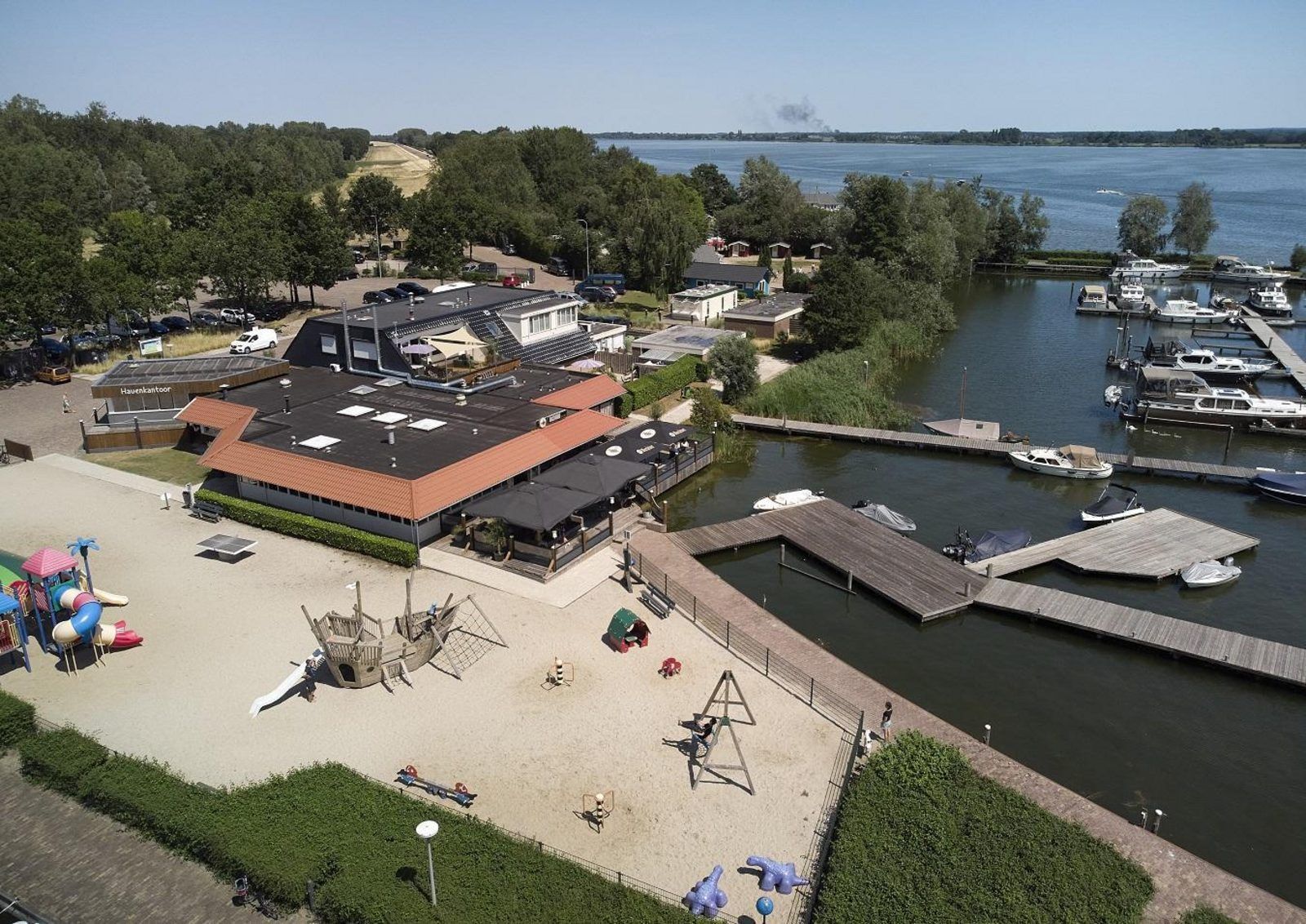 Aerial view of the marina at Safari Tent Wood, Biddinghuizen, with playground and water sports facilities in Flevoland.
