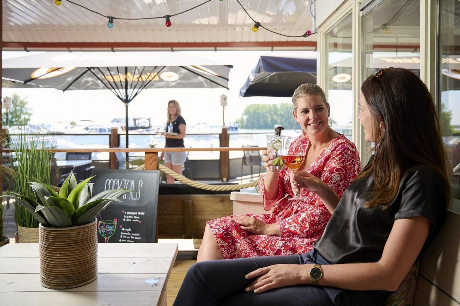 Cozy terrace at Safari Tent Wood, Biddinghuizen, overlooking the harbor and delicious cocktails in Flevoland.