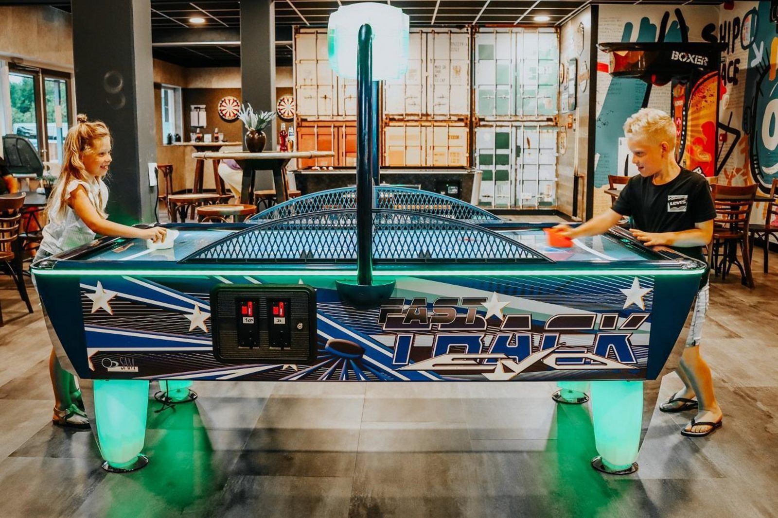 Children play air field hockey in the recreation room at Safari Tent Wood, Biddinghuizen, in Flevoland.