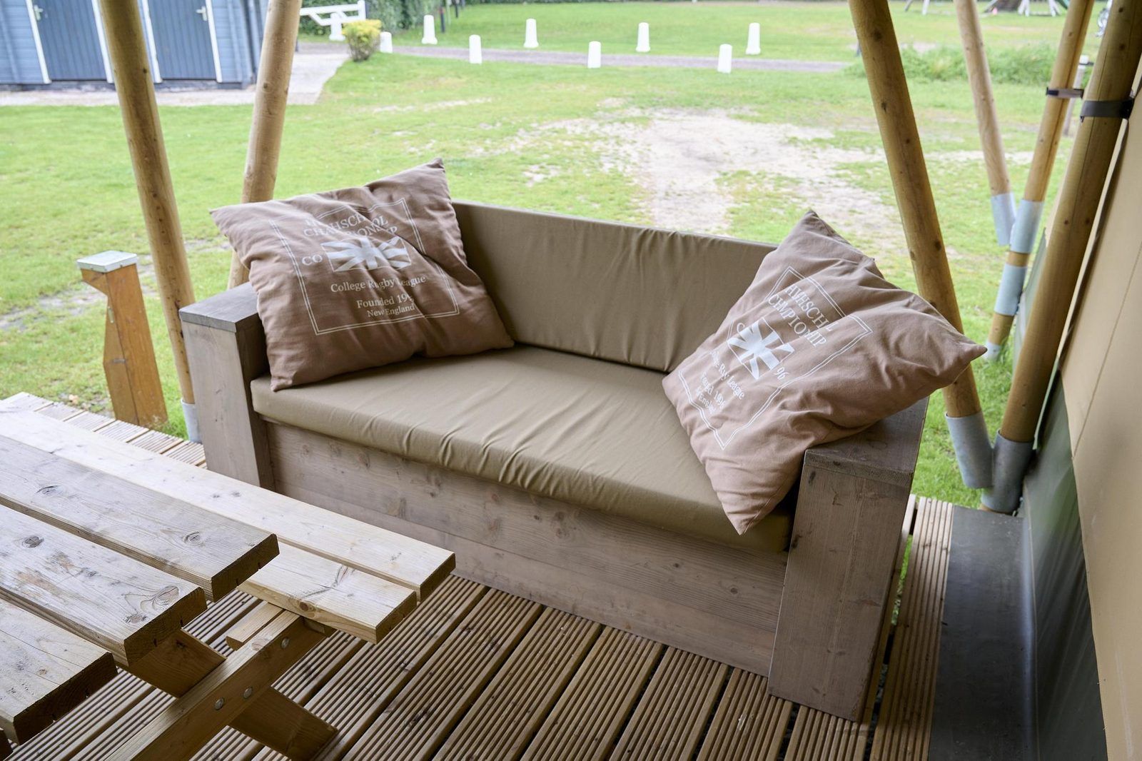 Holzbank mit Kissen auf der Veranda der Medley Lodge in Biddinghuizen, Ost-Flevoland, Flevoland.