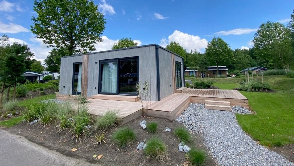 Chalet in Biddinghuizen, vakantiehuis in Oostelijk Flevoland met moderne buitenkant en houten terras.