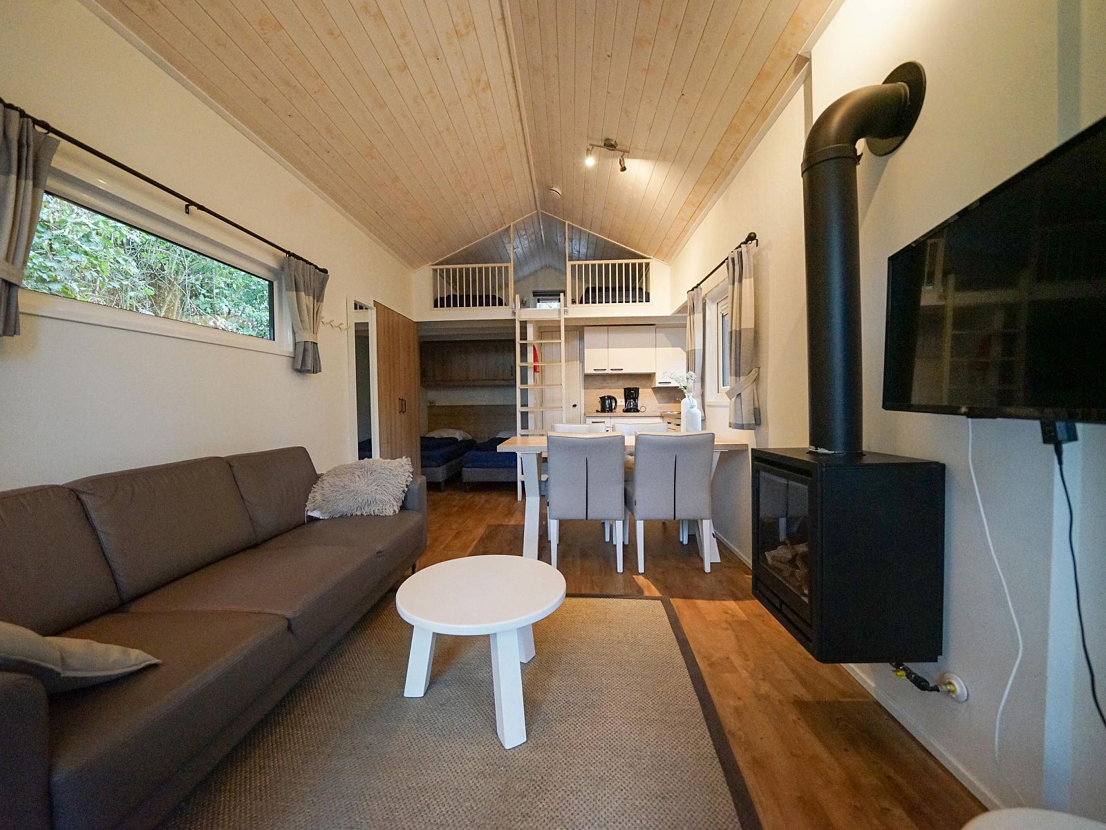 Gezellige woonkamer in de vrijstaande woning in Biddinghuizen, Flevoland met open haard en comfortabele zithoek.