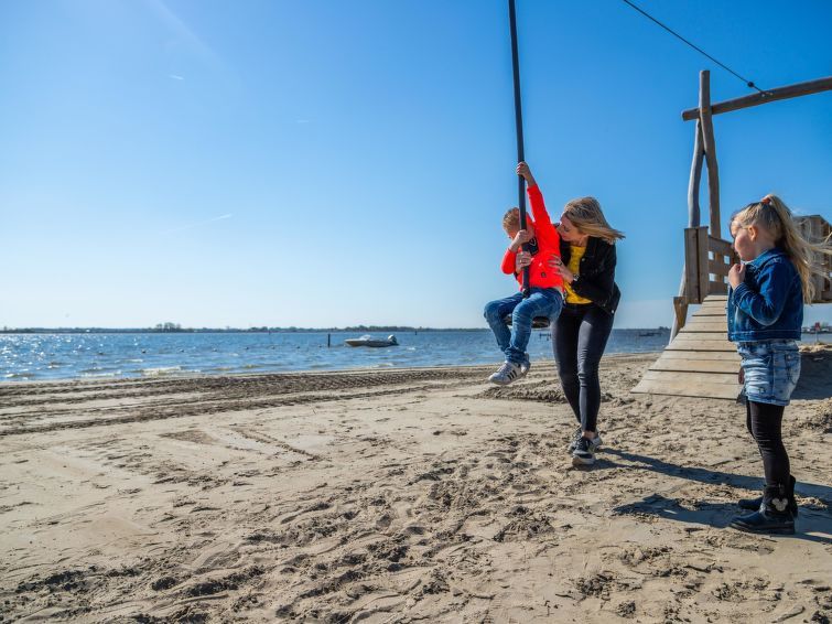 Strandactiviteiten bij Vakantiehuis Cube Elite 6, Biddinghuizen, Flevoland met kinderen die spelen bij het water.