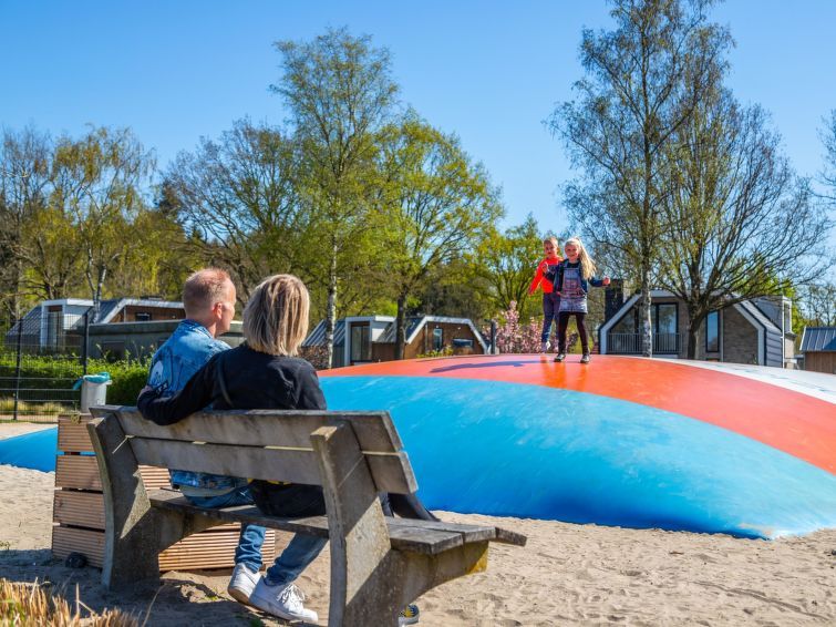 Kinderen spelen op springkussen in de buurt van Vakantiehuis Cube Elite 6, Biddinghuizen, Flevoland met ouders die toekijken.