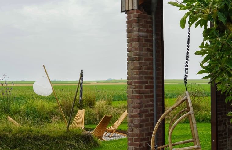 Geniessen Sie die laendliche Aussicht von der Veranda des Ferienhauses in Kraggenburg, das im gruenen Flevoland liegt.