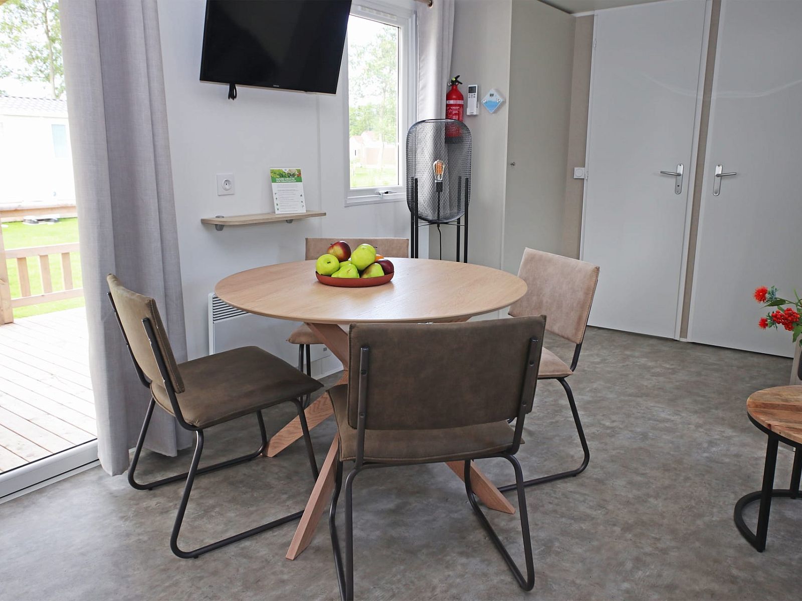 Gezellige eetruimte in Chalet de Krooneend, stacaravan in Zeewolde, Flevoland, met moderne inrichting en uitzicht op het terras.