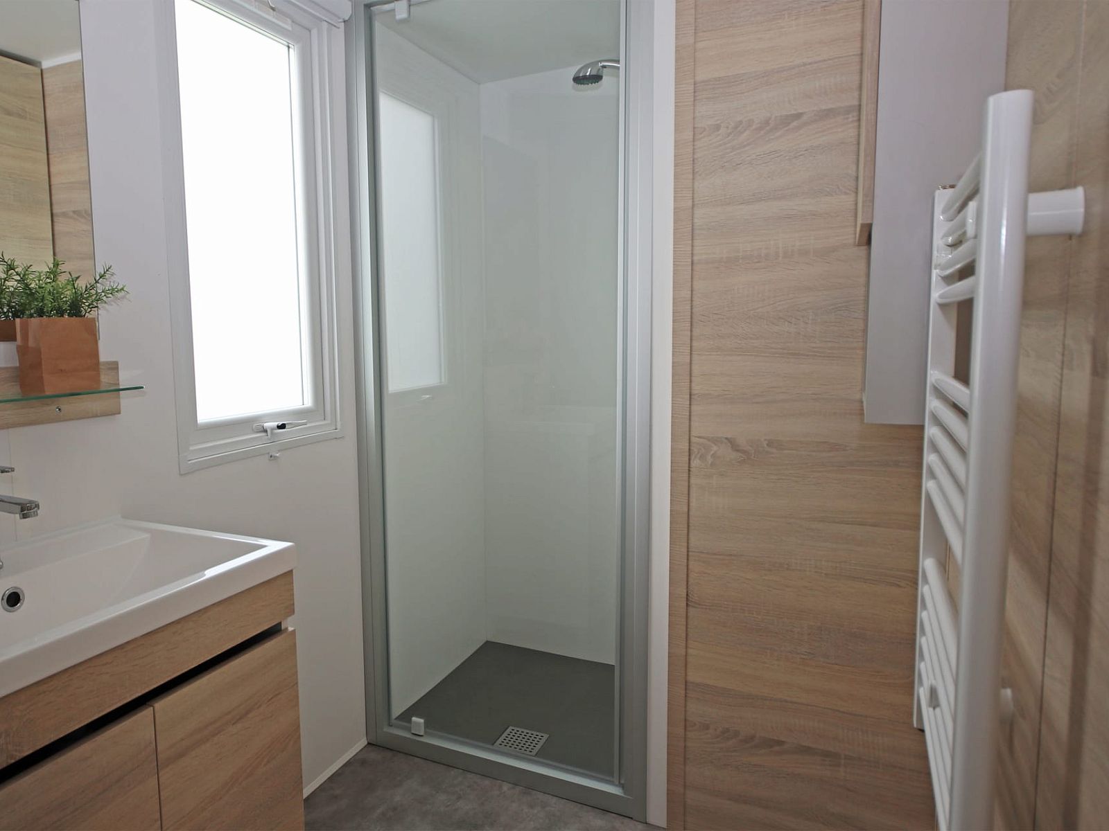 Moderne badkamer in Chalet de Krooneend, stacaravan in Zeewolde, Flevoland met stijlvolle douche en houten accenten.